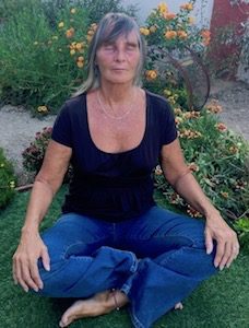 picture of older woman meditating in yard by Sabrina Santa Clara