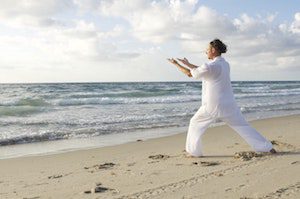 picture of man doing tai chi on beach